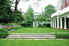 View across formal lawn flanked by fountain and gardens