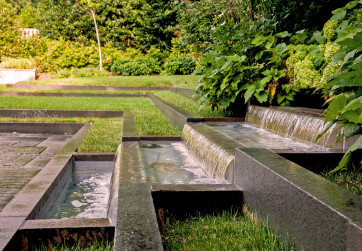 A stepped fountain slips into pool and sets lawns terraces
