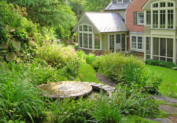 A millstone fountain draws guests to corner of garden