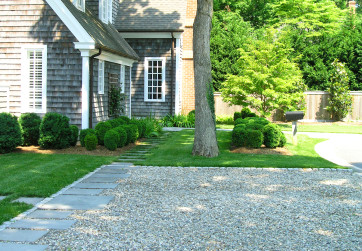A stone path seamlessly integrates the gravel drive and lawn creating a modern aesthetic