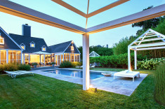 Wide stone coping surrounds a serene pool located in a lush lawn panel