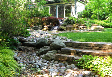 A dry riverbed is not only a gorgeous feature in this back garden but also an effective strategy to manage stormwater