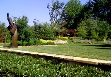 Stone retaining wall creating lawn and meadow path